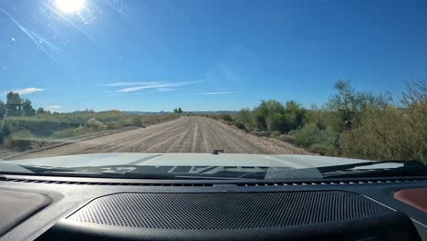 POV:-Conducir-Por-Un-Camino-De-Grava-A-Lo-Largo-Del-Canal-Principal-De-Gravedad-De-Gila-En-El-área-De-Vida-Silvestre-Del-Lago-Mittry-Cerca-De-Yuma,-Arizona