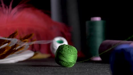 green-and-white-thread-slow-motion-red-feather-spool-bobbin-slow-motion