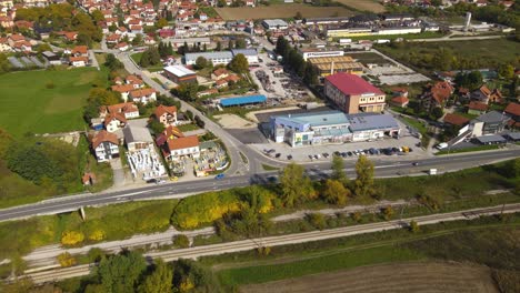 Vista-Aérea-De-Sevojno,-Pequeña-Ciudad-Industrial-En-El-Oeste-De-Serbia,-Paisaje-Verde-Y-Edificios-En-El-Soleado-Día-De-Otoño,-Revelando-Un-Disparo-Con-Drones-Inclinados-Hacia-Arriba