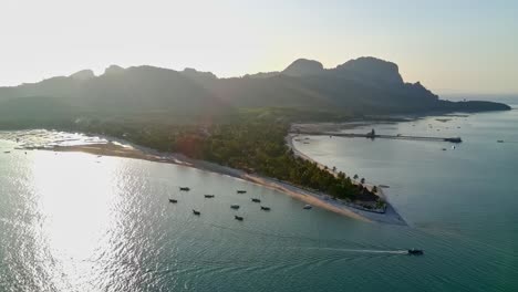 Half-orbit-drone-shot-of-sunset-Siwalai-beach-on-Koh-Mook-tropical-island-in-Andaman-sea-in-Trang,-southern-Thailand