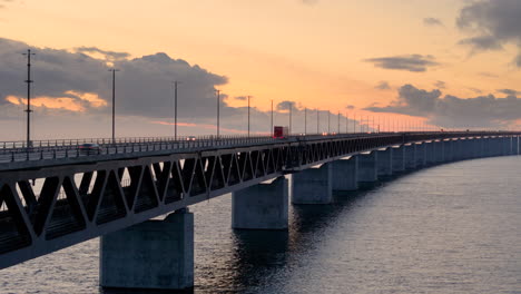 Vibrante-Cielo-Al-Atardecer-Con-Tráfico-Moviéndose-Sobre-El-Icónico-Puente-De-Oresund