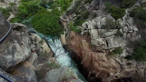 Slowmotion-tilt-view-of-water-falling-down-in-the-Caminito-del-Rey-in-Spain