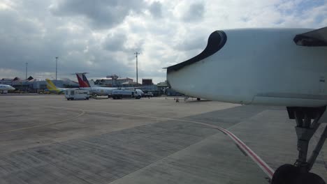 POV-of-airplane-passenger-at-the-window-side-near-the-wing-with-landing-gear-moving-to-park,-handheld