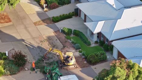 Yarrawonga,-Victoria,-Australia---6-March-2024:-Tree-felling-machine-loads-a-large-tree-branch-into-a-chipper-machine-in-a-suburban-street