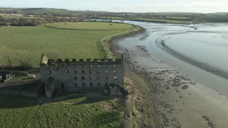 An-old-castle-on-the-river-blackwater-banks-in-county-cork,-ireland,-on-a-sunny-day,-aerial-view