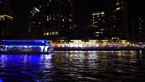 Dubai-Marina,-Vereinigte-Arabische-Emirate,-Touristenboot,-Das-Nachts-Auf-Der-Wasserstraße-Segelt