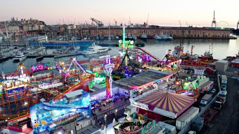 Birds'-eye-drone-view-over-Winter-Park-Genova-with-illuminated-rides-at-twilight