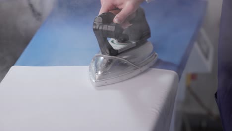 Female-Hand-Ironing-Clothes-At-Laundry-Shop