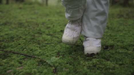 Astronaut-in-space-suit-walking-trough-forest