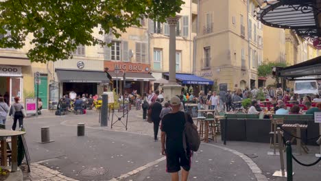 People-walk-by-restaurants-at-Place-des-Augustins-in-Aix-en-Provence