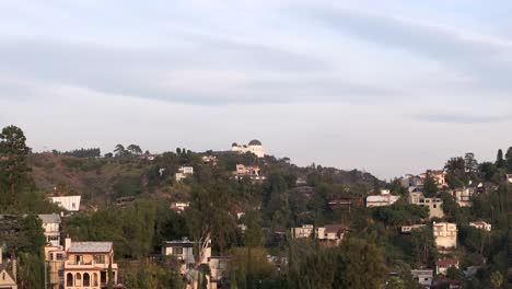 Aerial-reveal-of-Hollywood-hills-residential-neighborhood,-Griffith-Observatory-in-the-background