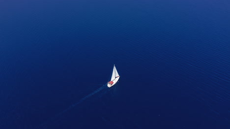 Aerial:-A-sailboat-is-sailing-in-the-open-calm-blue-sea