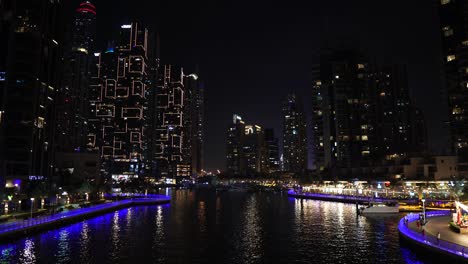 Puerto-Deportivo-De-Dubai,-Emiratos-Árabes-Unidos-Por-La-Noche,-Luces-En-Rascacielos-Y-Agua.