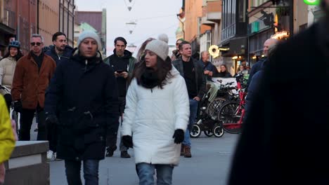 People-walk-on-pedestrian-street-on-weekend-in-Stockholm,-Sweden