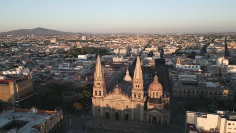 Aerial-Drone-Fly-Above-Guadalajara-Mexico-Church-landmark-Travel-City-historic-center,-Roman-Catholic-Building-Architecture-in-Sunset-around-local-traditional-houses