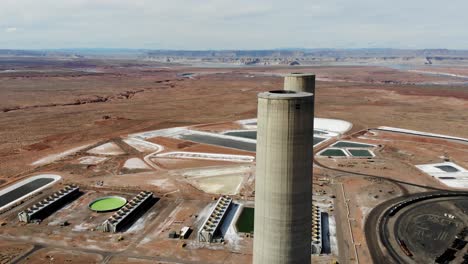 Eine-Drohnenaufnahme-Des-„Navajo-Generating-Station“,-Einem-Riesigen-Kohlekraftwerk-Und-Industriekomplex-Mit-Hohen-Schornsteinen,-Mitten-In-Der-Wüste-Der-Navajo-Nation,-In-Der-Nähe-Von-Page,-Arizona
