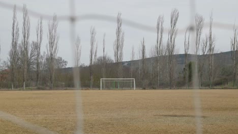 Campo-De-Fútbol-Amateur-Local-Vacío-En-Otoño-Disparado-Detrás-Del-Bokeh-En-Cámara-Lenta-De-La-Red-De-Los-Oponentes