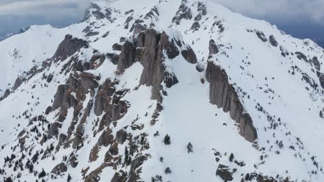 Montañas-Ciucas-Cubiertas-De-Nieve-Bajo-Un-Cielo-Nublado,-Vista-Aérea