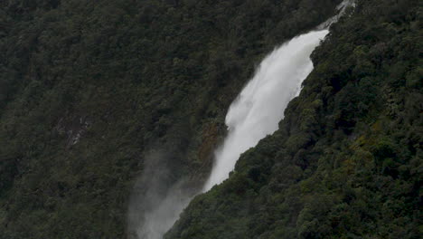 Slow-Motion-shot-of-a-large-waterfall-in-Milford-Sound-after-a-rain-storm---Piopiotahi,-New-Zealand