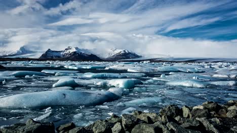 A-time-lapse-recording-captures-the-scenic-and-dramatic-landscape-of-melting-glaciers-under-a-blueish-sky,-creating-a-captivating-visual-narrative