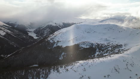 Snow-sunny-blizzard-Berthoud-Pass-Winter-Park-scenic-landscape-view-aerial-drone-sun-flare-backcountry-ski-snowboard-Berthod-Jones-Colorado-Rocky-Mountains-peaks-high-elevation-forward-motion
