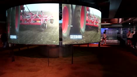Wide-shot-of-Digital-Displays-with-clip-of-tractor-seeding-at-Guiness-Storehouse