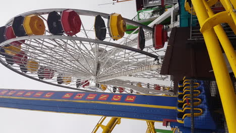 Vertical-Video,-Santa-Monica-Pier-Ferris-Wheel-and-Rollercoaster-California-USA