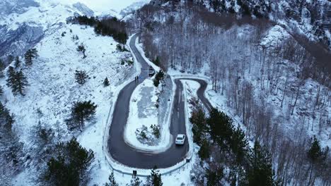 Aerial-snow-covered-mountain-range-with-U-turn-road-in-the-Albanian-mountains-of-Teth