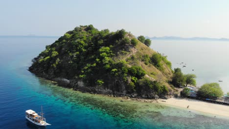 small-Pulau-Kelor-island-in-Komodo-Park,-Indonesia,-shot-from-a-drone-circling-around-it-to-showcase-its-beauty-from-all-angles