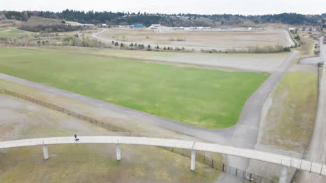Toma-Aérea-De-Drones-De-Vías-De-Tren-Debajo-De-Un-Puente-Peatonal-En-Tacoma,-Washington