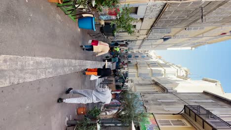People-walk-on-narrow-pedestrian-street-in-Marseille,-France,-vertical