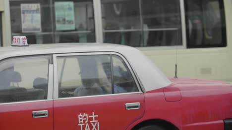 Hong-Kong-taxi-drives-along-in-traffic-with-passengers-in-back-seat---slow-motion