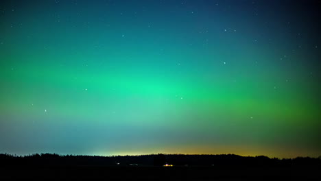 Time-Lapse-of-clouds-moving-over-vibrant-aurora-borealis-and-stars-on-a-night-sky