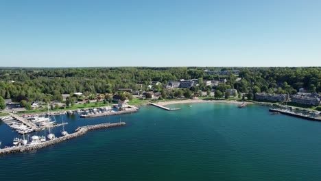 Disparo-Distante-De-Un-Dron-Del-Agua-De-Color-Turquesa-En-Sister-Bay,-Wisconsin.