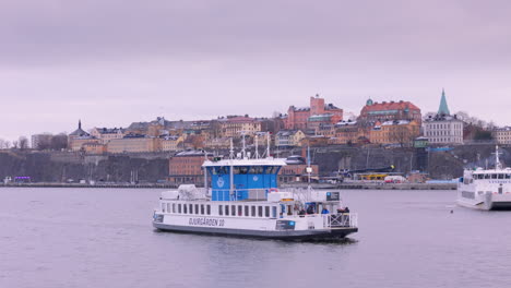 Djurgarden-commuter-ferry-cruising-with-Stockholm-skyline-background