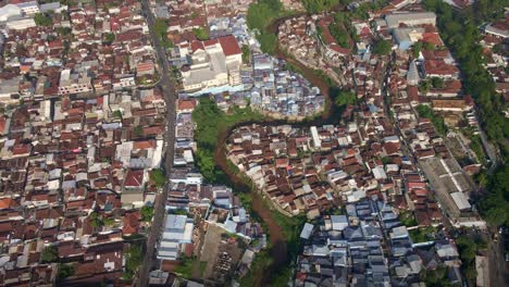 A-polluted-urban-river-runs-through-the-midst-of-an-overcrowded-population-area-in-Malang,-East-Java,-Indonesia