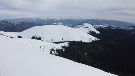 Vast-snowy-landscape-of-Iezer-Papusa-Mountains,-Romania,-with-forested-valleys