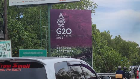 G20-Summit-Billboard-by-Busy-Road-on-Bali-Island,-Indonesia