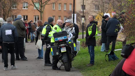 Polizisten-Mit-Motorrad-Stehen-Und-Reden-Bei-Protest-Gegen-Covid-Verordnung