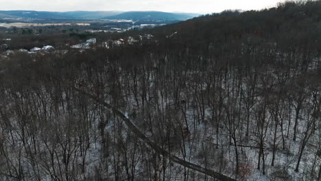 Aerial-drone-shot-of-snowy-leafless-forest-in-Mount-Sequoyah,-circle-pan