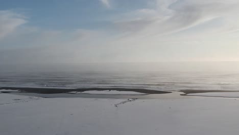 Nieve-Que-Cubre-La-Playa-De-Basalto-Negro-En-Islandia