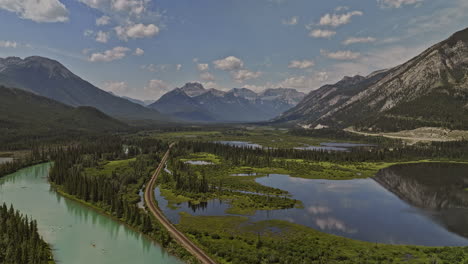 Banff-AB-Canada-Aerial-v46-flyover-forested-valley-capturing-the-picturesque-landscape-of-the-meandering-Bow-river,-wetland-lakes,-and-views-of-mountain-ranges---Shot-with-Mavic-3-Pro-Cine---July-2023