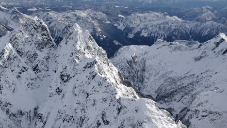 Rugged-Snowy-Mountain-Winter-Landscape-on-a-Sunny-Day---Aerial