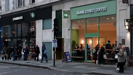 Walking-past-Starbucks-and-Blank-Street-Coffee,-London,-United-Kingdom