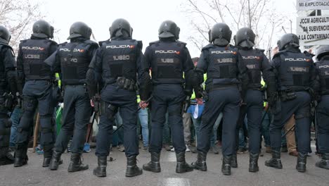 Polizisten-Stehen-Wache,-Als-Sich-Spanische-Landwirte-Und-Agrargewerkschaften-Auf-Der-Plaza-De-La-Independencia-Versammeln,-Um-Gegen-Unlauteren-Wettbewerb,-Agrar--Und-Regierungspolitik-Zu-Protestieren