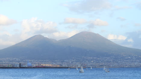 Static-shot-of-of-Mount-Vesuvius-and-city-of-Naples,-sailboats-sailing-in-foreground