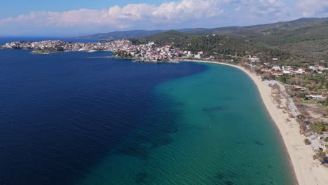 Aerial-view-of-the-long-beach-and-the-seaside-town-of-New-Marmaras-in-Sithonia-Chalkidiki