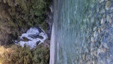 Vertikale-Ansicht-Der-Malerischen-Fantail-Falls-Mit-Dem-Gletscherfluss-Davor,-Umgeben-Von-Einheimischem-Buschwerk-An-Der-Westküste-Neuseelands