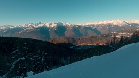 Vista-De-Un-Valle-Nevado-Con-Un-Pueblo-Desde-Una-Pista-De-Esquí-En-Los-Alpes,-Vista-Amplia