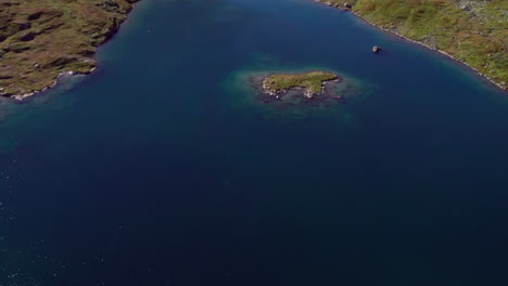 Aerial-shot-looking-down-at-the-shoreline-of-a-Fjord-in-Haukelifjell,-Norway